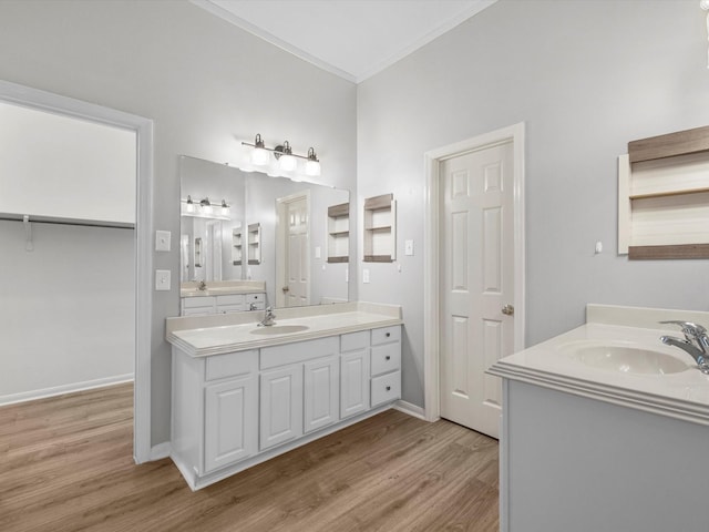 3910 Echo Mountain Dr, Kingwood, TX 77345 - full bathroom featuring wood finished floors, two vanities, crown molding, baseboards, and a closet