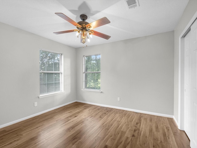 3910 Echo Mountain Dr, Kingwood, TX 77345 - unfurnished bedroom with wood finished floors, baseboards, a ceiling fan, and a closet