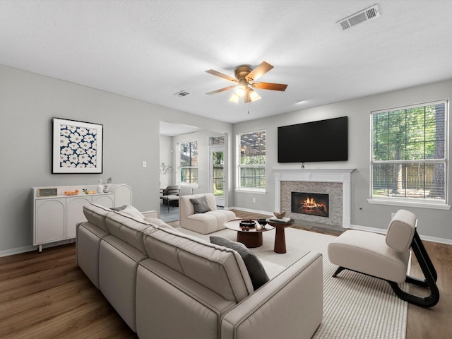 3910 Echo Mountain Dr, Kingwood, TX 77345 - living area featuring wood finished floors, baseboards, a ceiling fan, and a fireplace with flush hearth