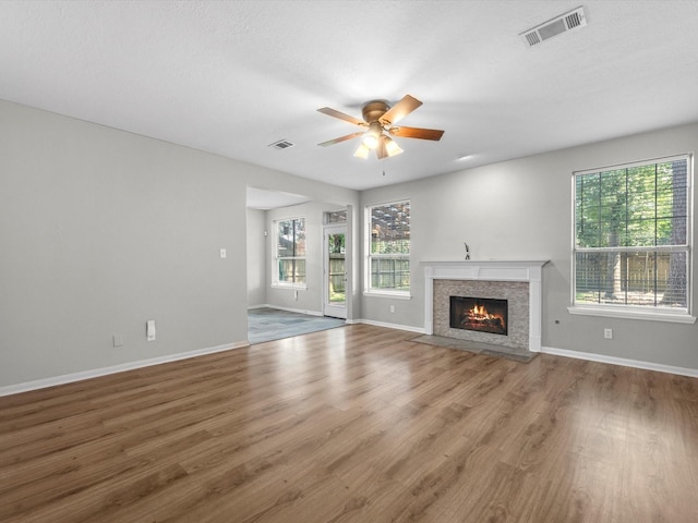 3910 Echo Mountain Dr, Kingwood, TX 77345 - unfurnished living room with a ceiling fan, wood finished floors, baseboards, and a fireplace with flush hearth