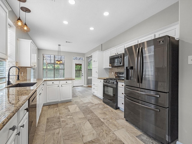 3910 Echo Mountain Dr, Kingwood, TX 77345 - kitchen with stainless steel appliances, a sink, white cabinetry, recessed lighting, and tasteful backsplash