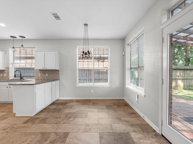 3910 Echo Mountain Dr, Kingwood, TX 77345 - kitchen with a sink, plenty of natural light, backsplash, and white cabinets
