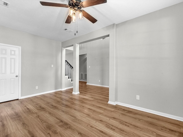 3910 Echo Mountain Dr, Kingwood, TX 77345 - spare room featuring wood finished floors, a ceiling fan, stairs, and baseboards