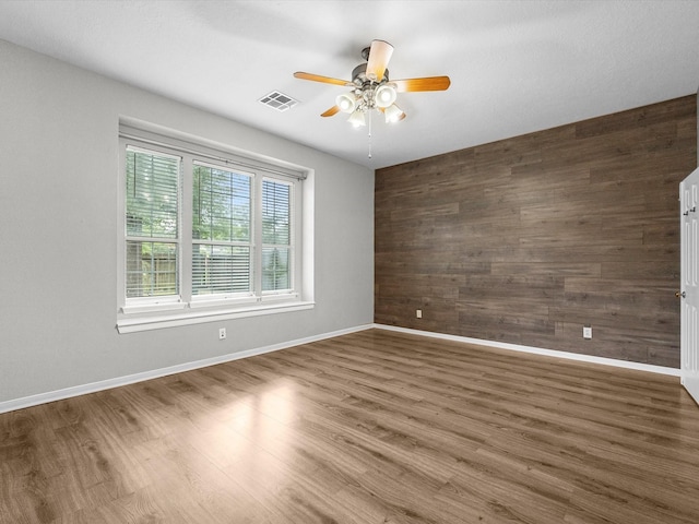 3910 Echo Mountain Dr, Kingwood, TX 77345 - spare room with wooden walls, a ceiling fan, wood finished floors, and baseboards
