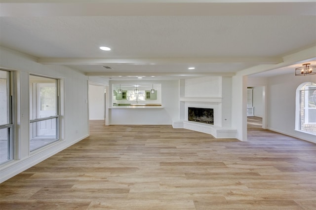 127 Red Bud Ln, Baytown, TX 77520 - unfurnished living room with a chandelier, light wood-type flooring, a brick fireplace, recessed lighting, and baseboards