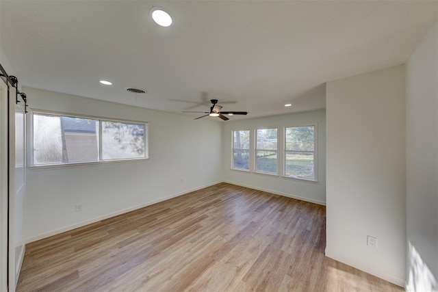 127 Red Bud Ln, Baytown, TX 77520 - spare room featuring light wood finished floors, a barn door, recessed lighting, baseboards, and a ceiling fan