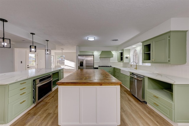 127 Red Bud Ln, Baytown, TX 77520 - kitchen with green cabinets, open shelves, appliances with stainless steel finishes, a kitchen island, and light wood finished floors