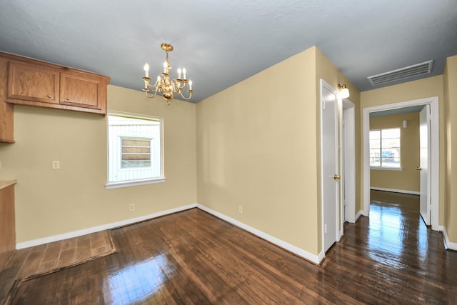149 E Riverwood Dr, Houston, TX 77076 - unfurnished dining area featuring a chandelier, dark wood-style flooring, and baseboards