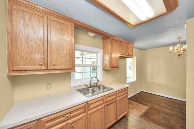 149 E Riverwood Dr, Houston, TX 77076 - kitchen featuring a sink, dark wood-type flooring, light countertops, a chandelier, and baseboards