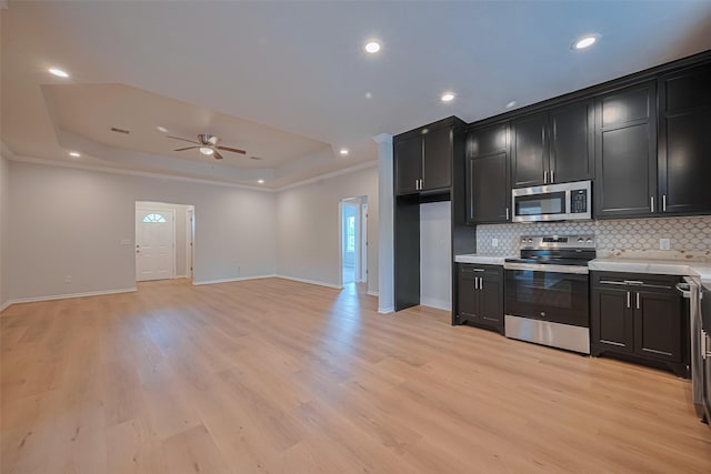 4523 Nexus Rd, Houston, TX 77053 - kitchen featuring appliances with stainless steel finishes, dark cabinetry, a raised ceiling, tasteful backsplash, and light countertops