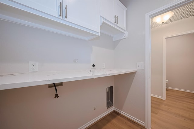 4523 Nexus Rd, Houston, TX 77053 - laundry room with cabinet space, light wood-type flooring, electric dryer hookup, baseboards, and a desk