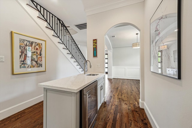 5204 Chestnut St, Bellaire, TX 77401 - hallway featuring wine cooler, crown molding, dark wood finished floors, arched walkways, and a sink