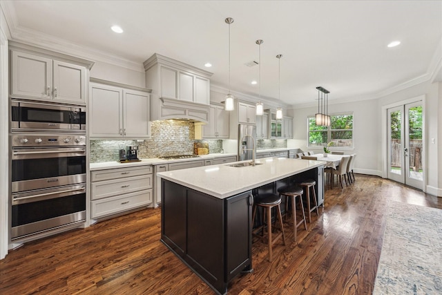 5204 Chestnut St, Bellaire, TX 77401 - kitchen featuring a sink, appliances with stainless steel finishes, dark wood-style flooring, decorative backsplash, and crown molding