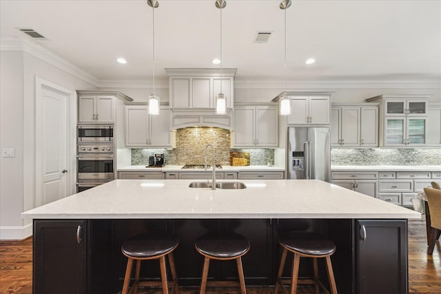 5204 Chestnut St, Bellaire, TX 77401 - kitchen with appliances with stainless steel finishes, a large island with sink, backsplash, a kitchen breakfast bar, and crown molding