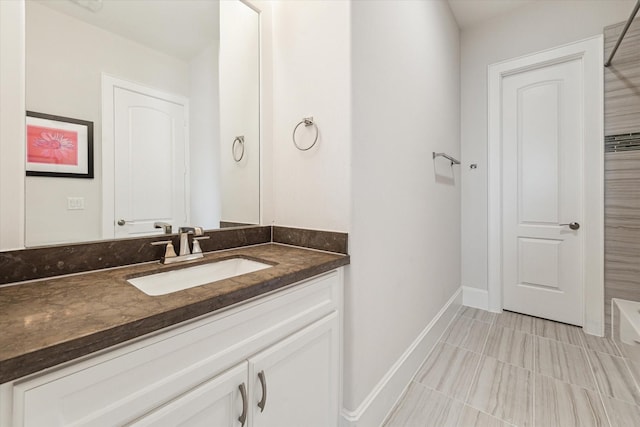 5204 Chestnut St, Bellaire, TX 77401 - bathroom with vanity, baseboards, a tub to relax in, and tile patterned floors