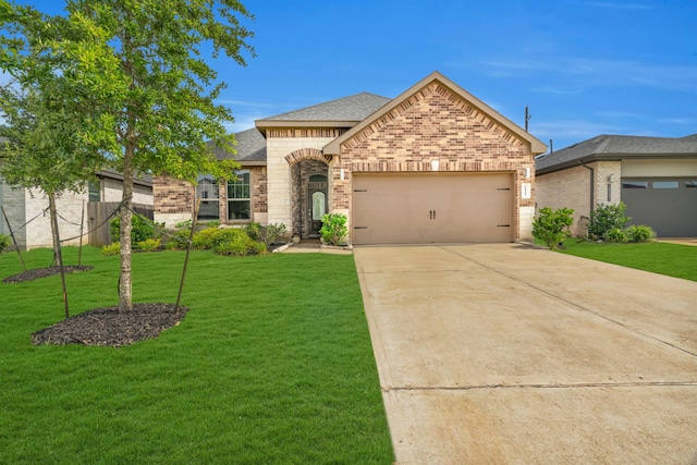 28403 Hannahs Harbor Ln, Katy, TX 77494 - french country style house featuring brick siding, an attached garage, a front yard, concrete driveway, and roof with shingles