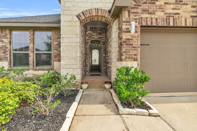 28403 Hannahs Harbor Ln, Katy, TX 77494 - property entrance featuring brick siding, an attached garage, and a shingled roof