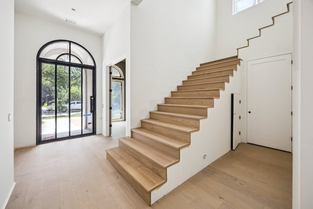 1656 Banks St, Houston, TX 77006 - foyer entrance featuring stairs, light wood-style flooring, and a towering ceiling