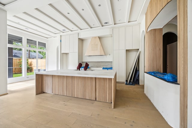 1656 Banks St, Houston, TX 77006 - kitchen with modern cabinets, arched walkways, a kitchen island, light wood-style floors, and light countertops