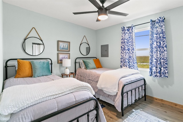 334 Bay Ave, Surfside Beach, TX 77541 - bedroom featuring wood finished floors, electric panel, baseboards, and ceiling fan