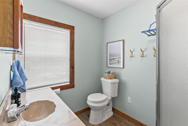334 Bay Ave, Surfside Beach, TX 77541 - bathroom with wood finished floors, toilet, vanity, and baseboards