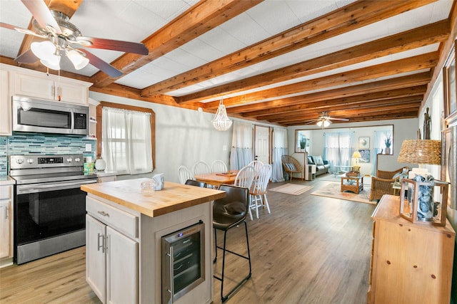 334 Bay Ave, Surfside Beach, TX 77541 - kitchen with stainless steel appliances, butcher block counters, ceiling fan, wine cooler, and open floor plan