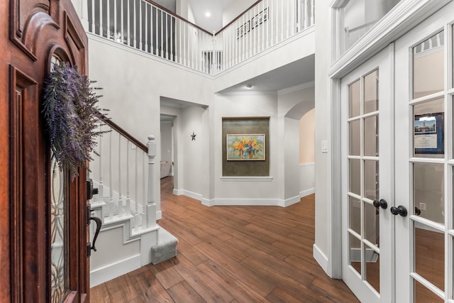14 Brywood Pl, The Woodlands, TX 77382 - foyer entrance featuring arched walkways, french doors, baseboards, ornamental molding, and stairway