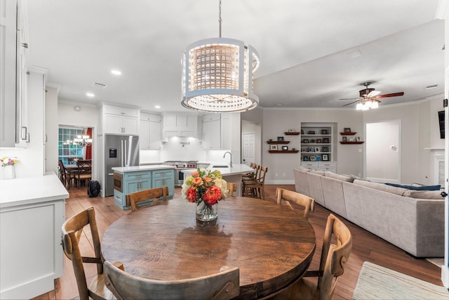 14 Brywood Pl, The Woodlands, TX 77382 - dining area with ornamental molding, light wood-style flooring, a chandelier, ceiling fan, and recessed lighting
