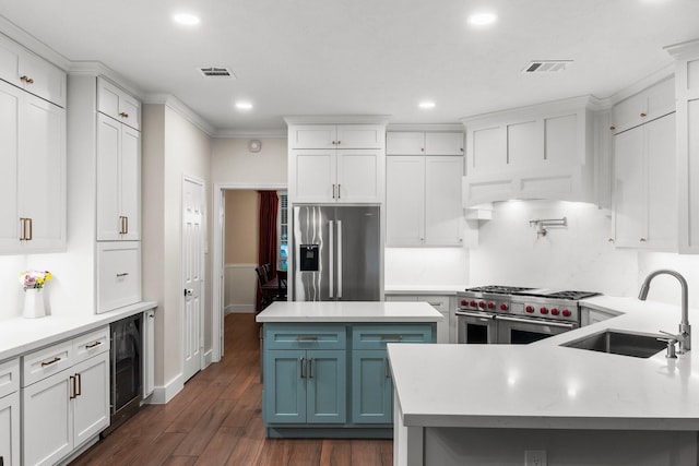 14 Brywood Pl, The Woodlands, TX 77382 - kitchen with appliances with stainless steel finishes, a sink, beverage cooler, light countertops, and dark wood finished floors