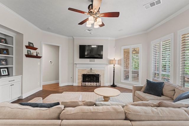 14 Brywood Pl, The Woodlands, TX 77382 - living room with ornamental molding, a tiled fireplace, a ceiling fan, wood finished floors, and baseboards