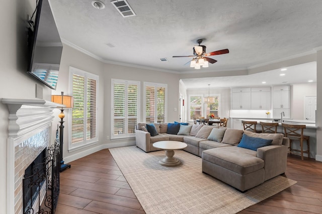 14 Brywood Pl, The Woodlands, TX 77382 - living area featuring a fireplace, wood-type flooring, ornamental molding, baseboards, and plenty of natural light