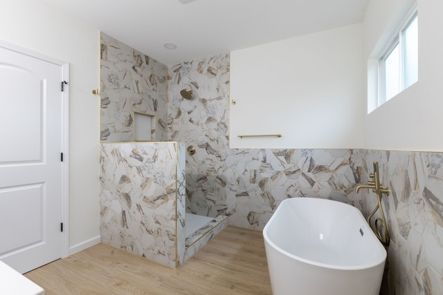 509 W Sixth St, Brenham, TX 77833 - bathroom with tile walls, walk in shower, a freestanding tub, and wood finished floors
