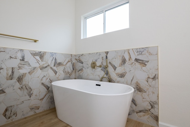 509 W Sixth St, Brenham, TX 77833 - full bath featuring a freestanding tub, tile walls, and wood finished floors