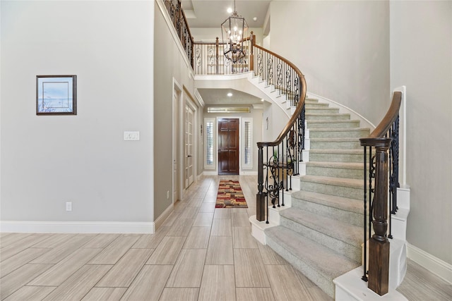 3310 Ralston Edge Ln, Houston, TX 77059 - foyer entrance featuring stairway, a chandelier, baseboards, a towering ceiling, and wood tiled floors