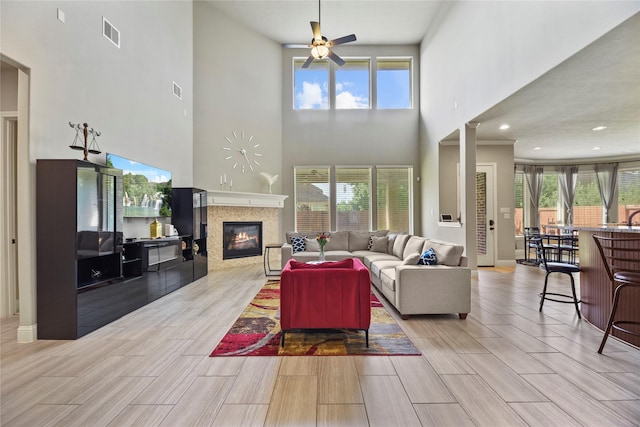 3310 Ralston Edge Ln, Houston, TX 77059 - living area with a glass covered fireplace, a towering ceiling, a ceiling fan, and wood tiled floors