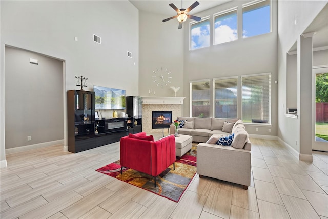 3310 Ralston Edge Ln, Houston, TX 77059 - living area featuring a high ceiling, baseboards, a ceiling fan, a fireplace, and wood finish floors