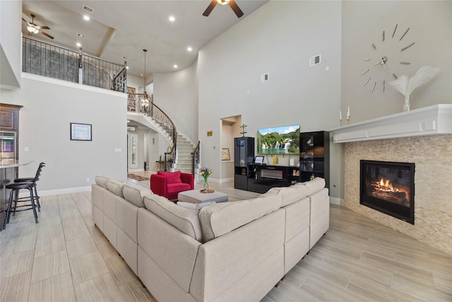 3310 Ralston Edge Ln, Houston, TX 77059 - living room featuring ceiling fan, stairs, recessed lighting, a tile fireplace, and a towering ceiling
