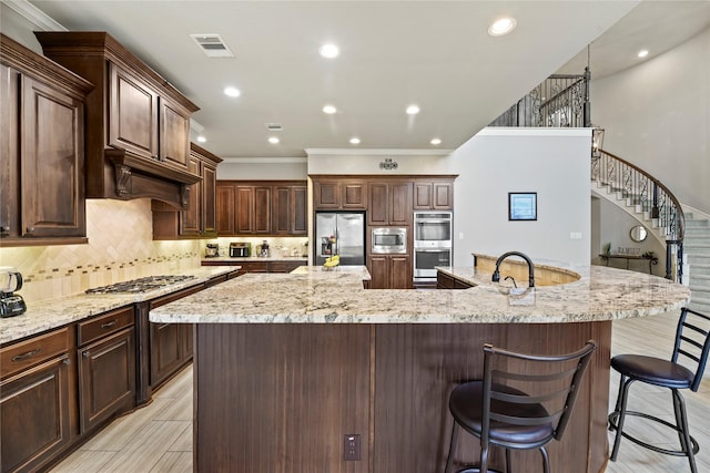 3310 Ralston Edge Ln, Houston, TX 77059 - kitchen with stainless steel appliances, a spacious island, a breakfast bar, crown molding, and backsplash