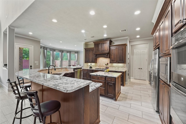 3310 Ralston Edge Ln, Houston, TX 77059 - kitchen with a large island with sink, ornamental molding, a sink, recessed lighting, and backsplash
