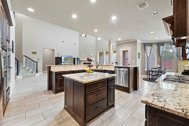 3310 Ralston Edge Ln, Houston, TX 77059 - kitchen featuring appliances with stainless steel finishes, a spacious island, a sink, dark brown cabinets, and recessed lighting