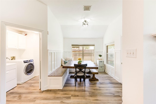 12006 Bright Landing Ct, Pearland, TX 77584 - dining room with breakfast area, washing machine and clothes dryer, light wood-type flooring, a decorative wall, and a wainscoted wall