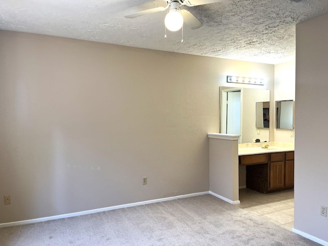 21007 Rivershadows Ln, Spring, TX 77388 - unfurnished bedroom with light colored carpet, a textured ceiling, baseboards, connected bathroom, and a sink
