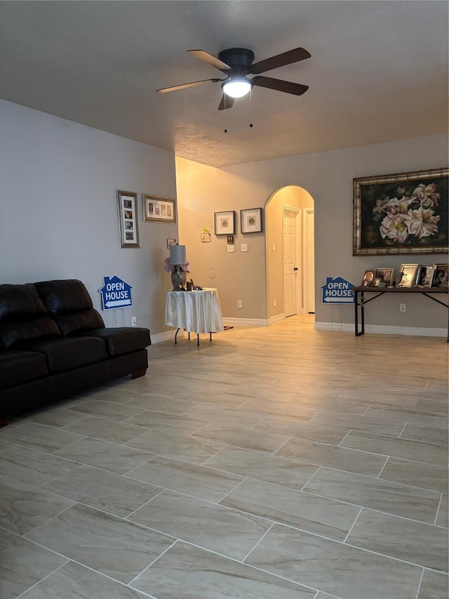 7415 Bering Landing Dr, Cypress, TX 77433 - living room featuring arched walkways, a ceiling fan, and baseboards
