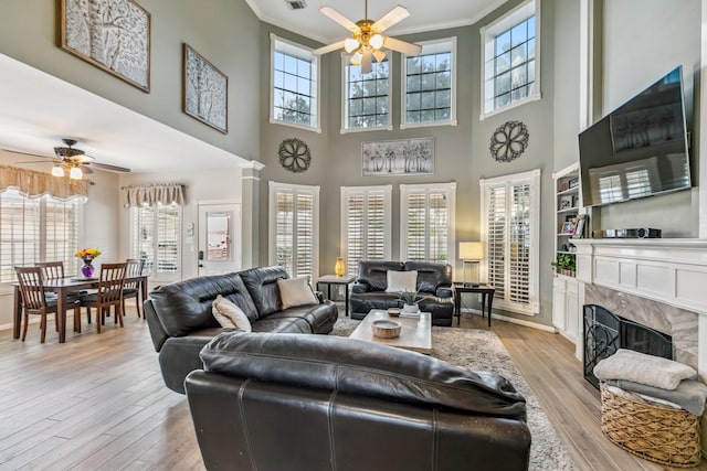 16342 Granite Park Ct, Cypress, TX 77429 - living room featuring a ceiling fan, crown molding, plenty of natural light, light wood-type flooring, and a towering ceiling