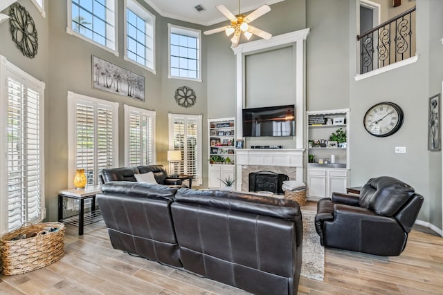 16342 Granite Park Ct, Cypress, TX 77429 - living area featuring a towering ceiling, ceiling fan, wood finished floors, a fireplace, and crown molding