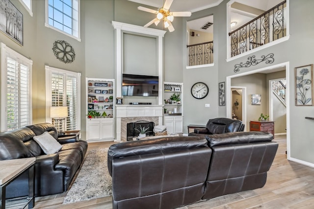 16342 Granite Park Ct, Cypress, TX 77429 - living area featuring a high ceiling, a ceiling fan, a high end fireplace, wood finished floors, and baseboards