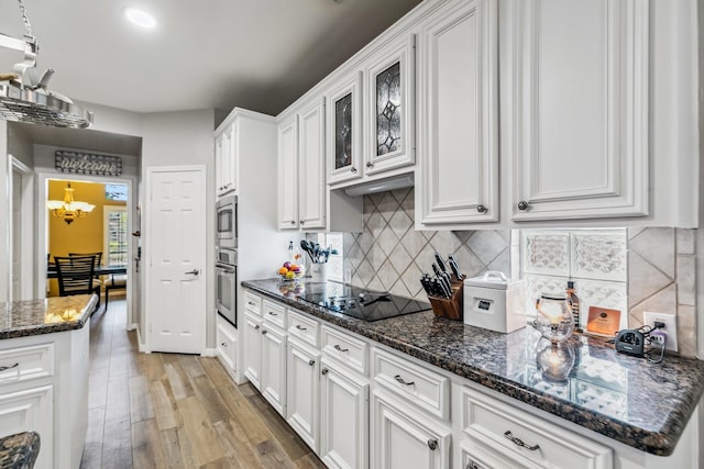 16342 Granite Park Ct, Cypress, TX 77429 - kitchen with stainless steel appliances, white cabinets, light wood-style flooring, backsplash, and a chandelier