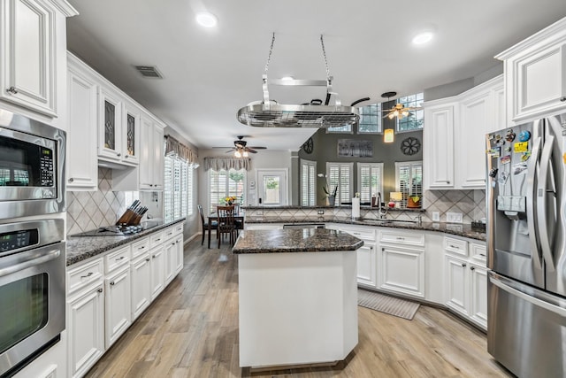 16342 Granite Park Ct, Cypress, TX 77429 - kitchen featuring stainless steel appliances, ceiling fan, a peninsula, decorative backsplash, and recessed lighting