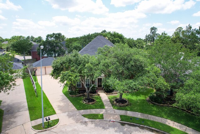 16342 Granite Park Ct, Cypress, TX 77429 - view of property hidden behind natural elements featuring concrete driveway, a front yard, and a garage