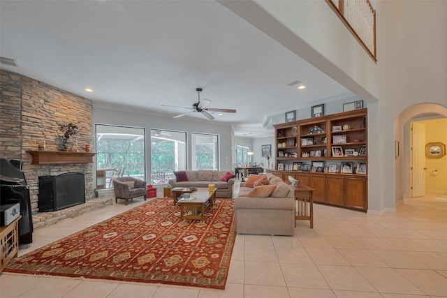 12214 Francel Ln, Cypress, TX 77429 - living room featuring a ceiling fan, light tile patterned floors, arched walkways, a fireplace, and recessed lighting